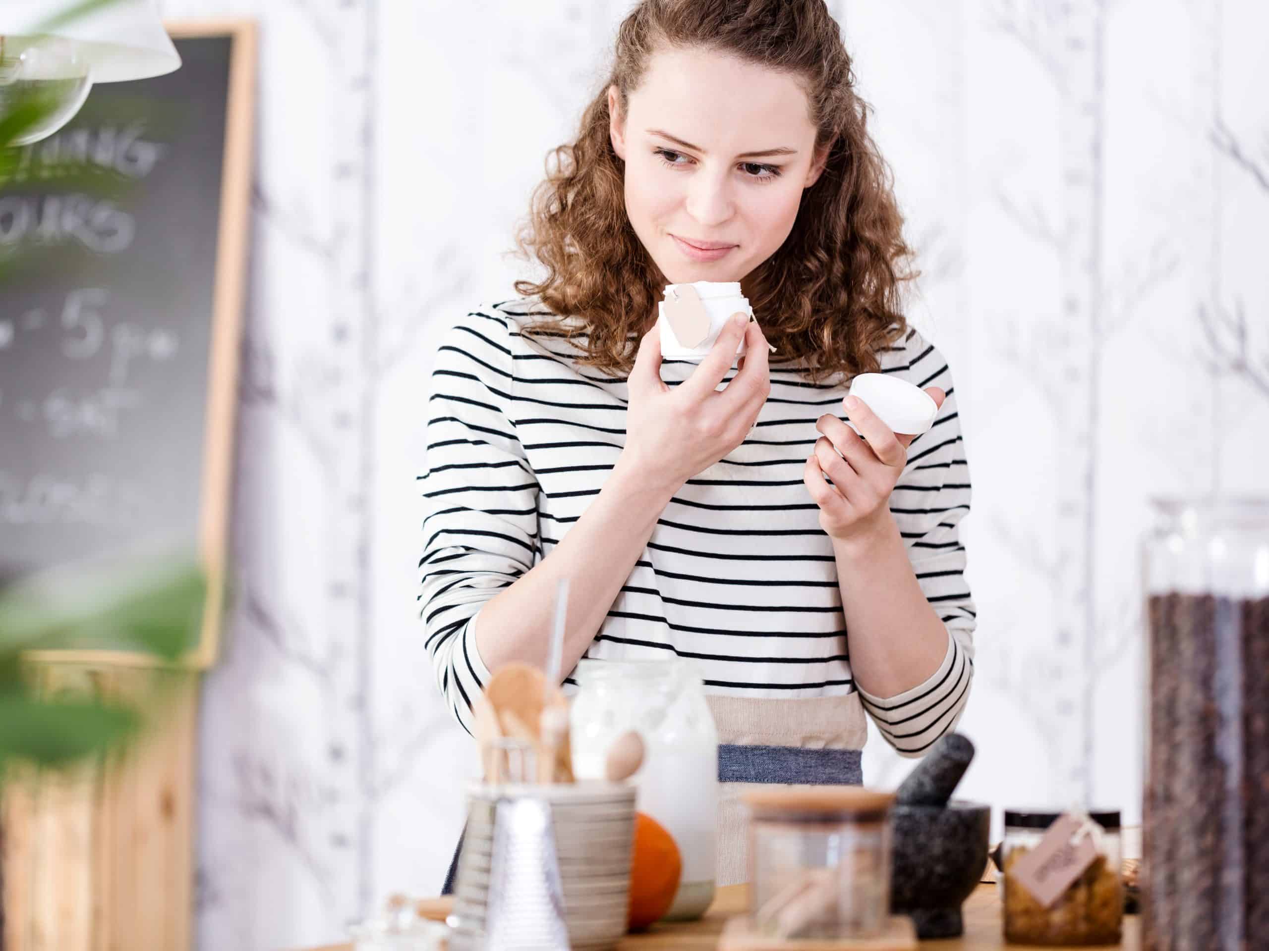 Woman smelling organic soaps while standing in a cosmetic shop